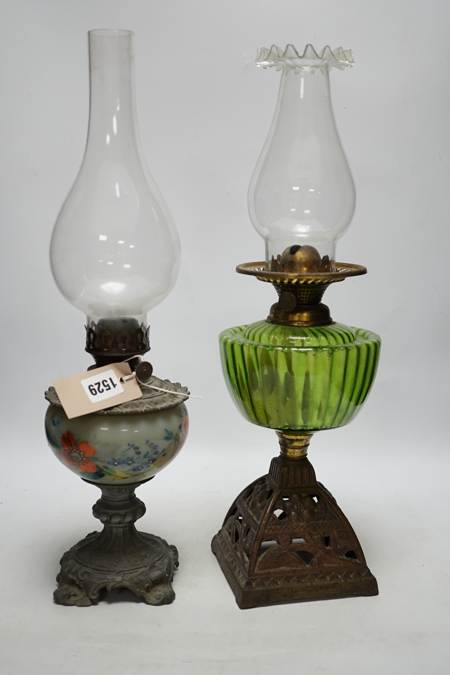 Two oil lamp bases with glass reservoirs, largest 48cm high